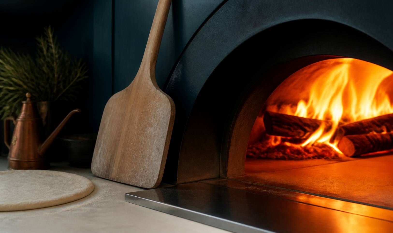 Four à pizza à bois avec flammes et pelle en bois